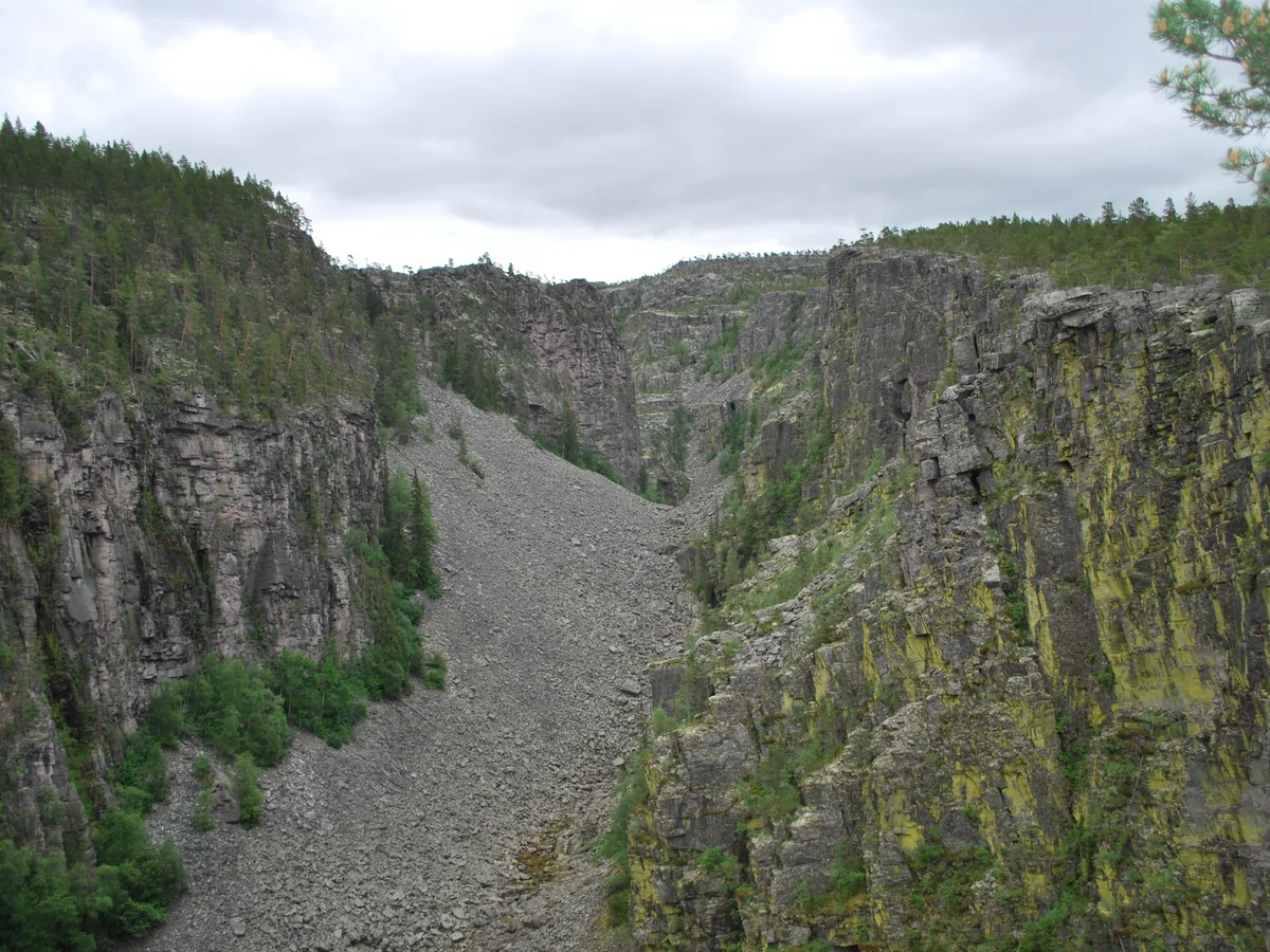 Jutulhogget: den dype canyonen med steile, lavdekte klippevegger og en ur av grå stein i bunnen
